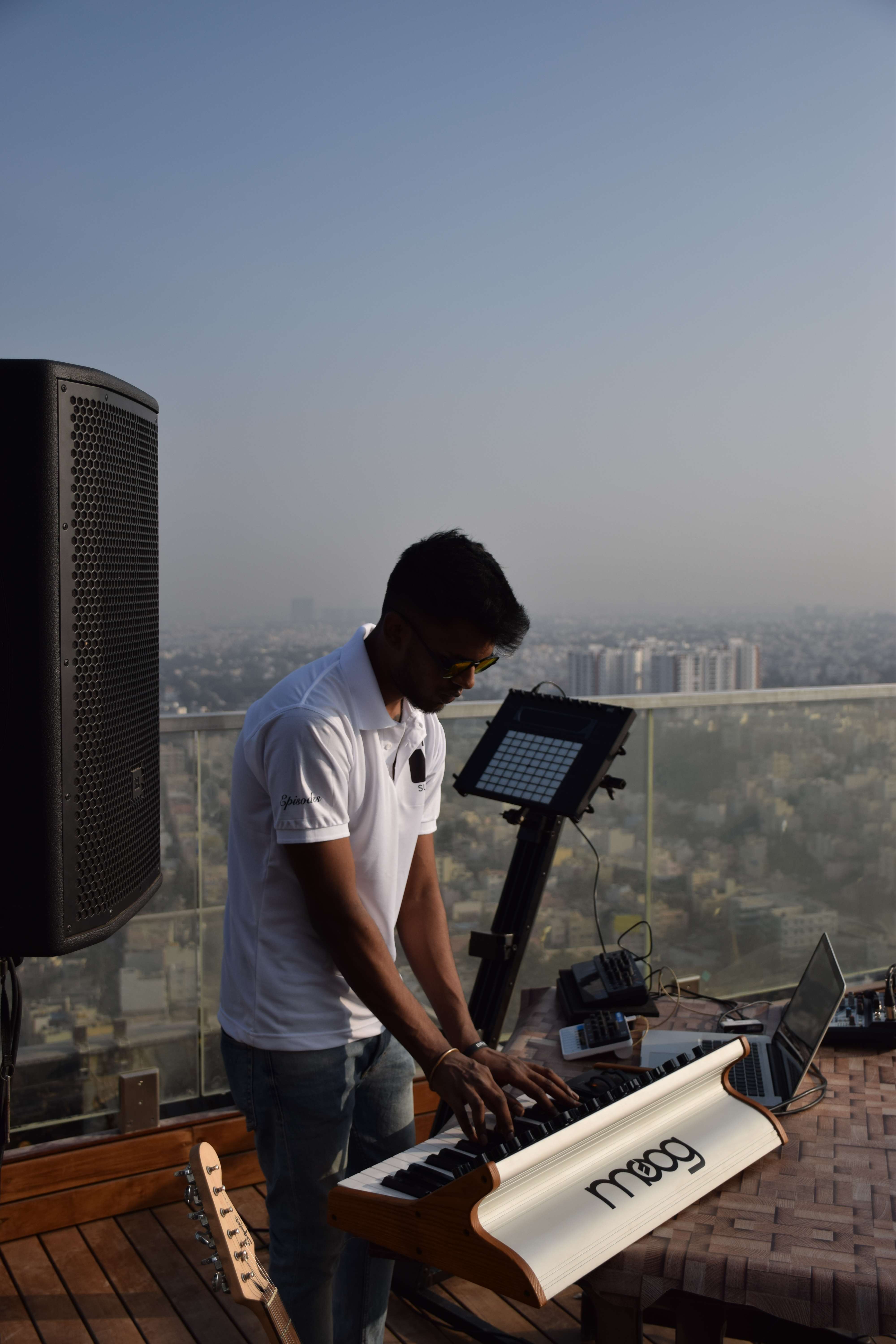 Nirupan performing on a Moog synthesizer against a city skyline